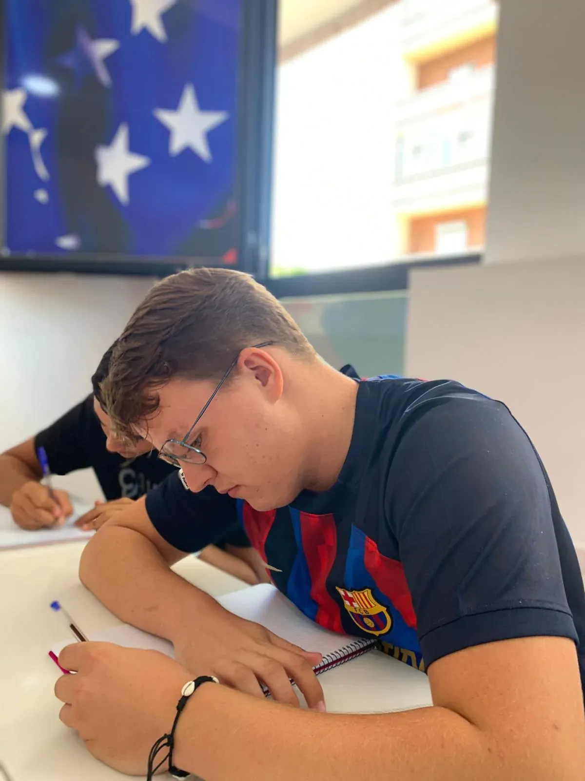 Alumno realizando una actividad escrita en clase