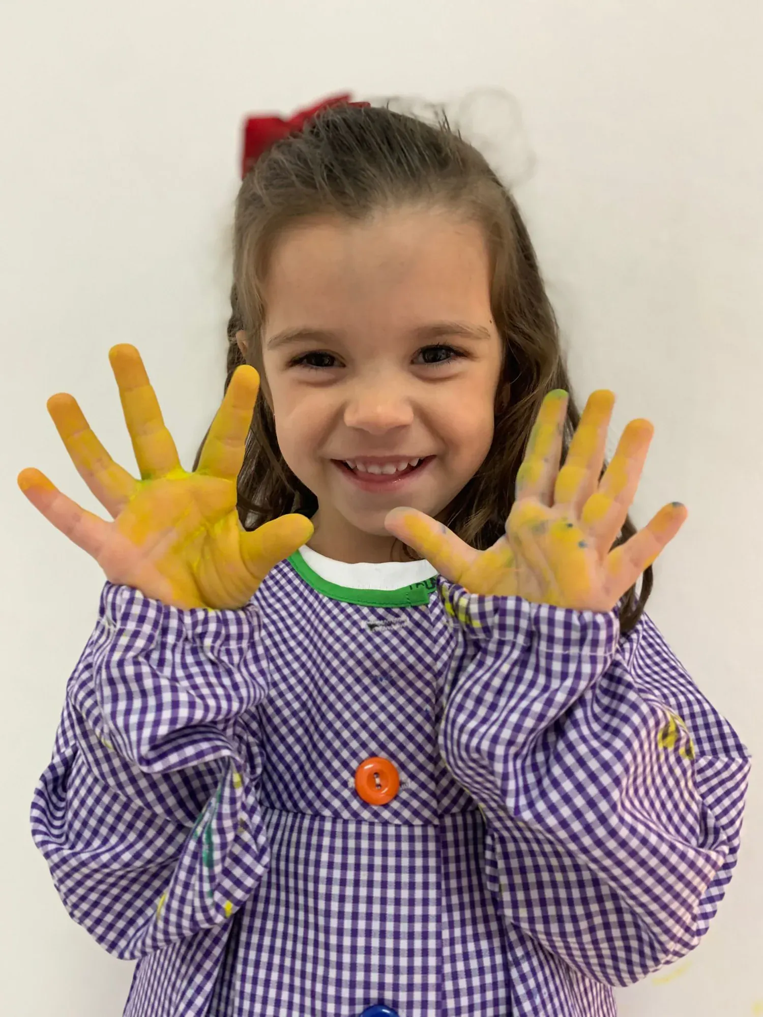 Alumna de Infantil mostrando sus manos pintadas