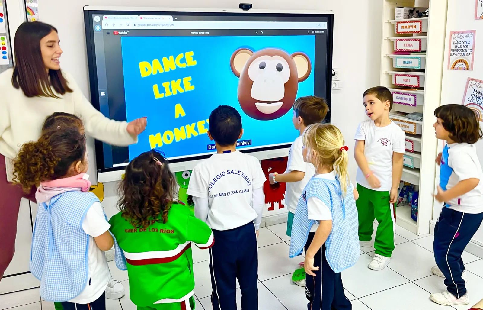 Niños bailando y moviéndose siguiendo una canción en la pizarra
